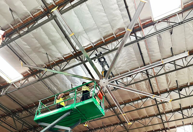 Employees installing a Big Ass Fan inside a commercial building