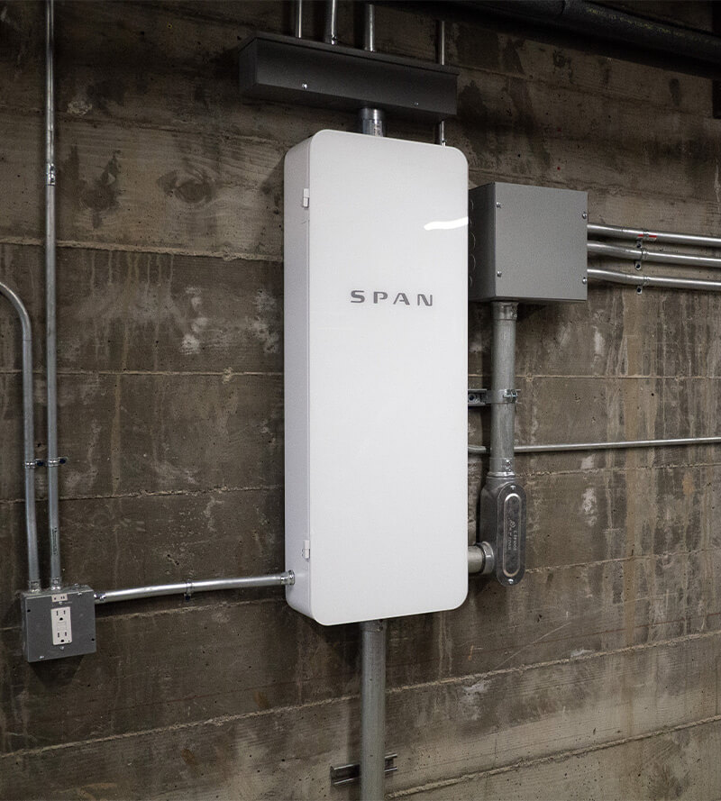 SPAN smart electrical panel installed in garage with exposed conduit, showcasing modern energy management system in Southern California home