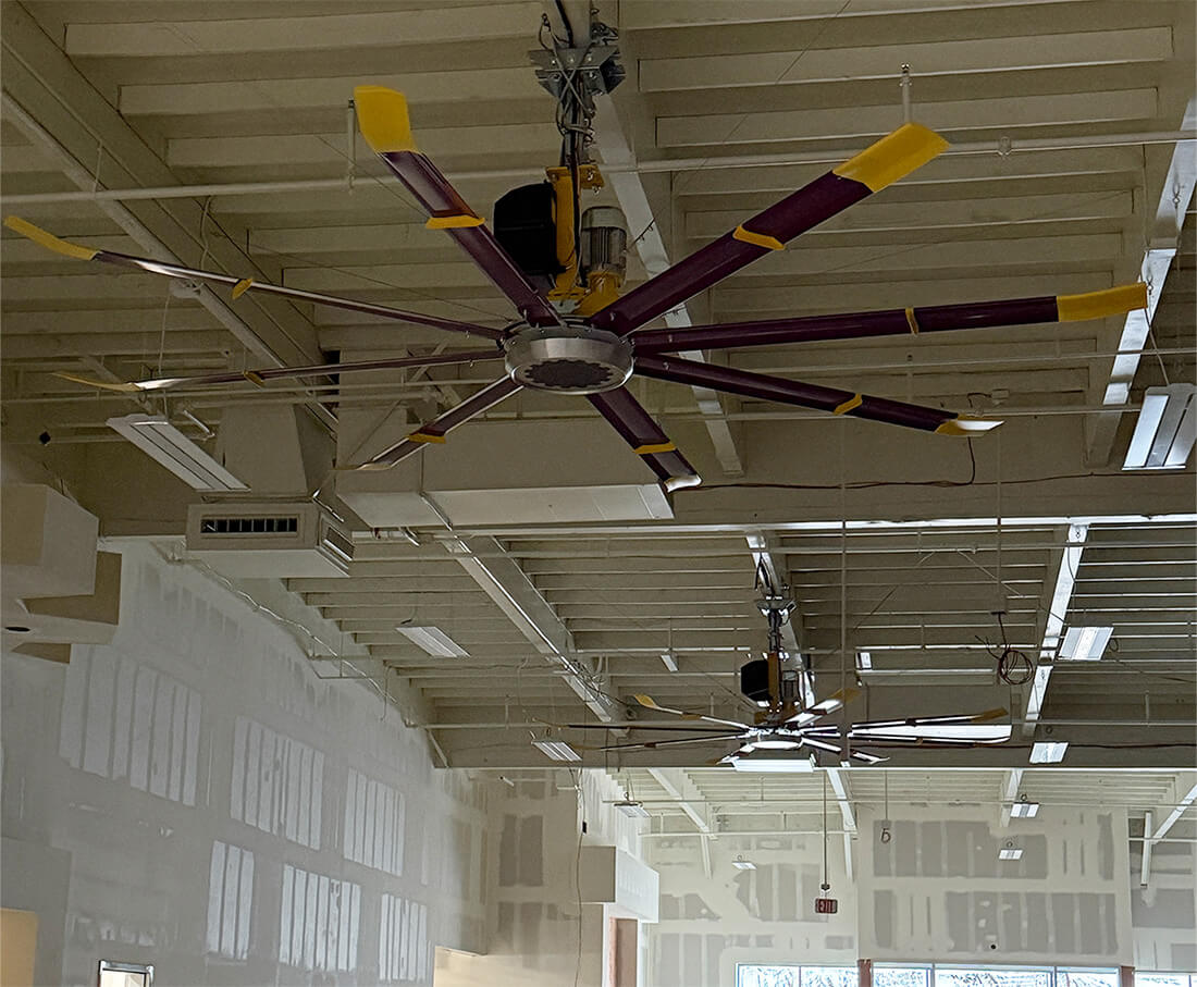 multiple HVLS ceiling fans installed in Planet Fitness gym during construction to improve airflow and cooling efficiency in Southern California