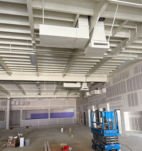 Planet Fitness gym interior under construction with exposed ceiling ductwork and HVAC installation in Southern California